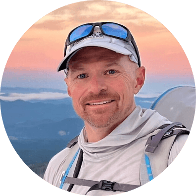 Gavin Woody hiking with rolling hills and low fog behind him